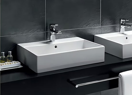 Baltas keraminis pakabinamas praustuvas Ideal Standard Strada 71x42 cm su anga pro maišytuvui per vidurį.