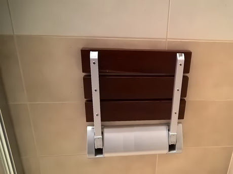 Atlenkiamos dušo sėdynė Multi rudos spalvos, iš masyvios Bulletwood medienos, su sieniniu laikikliu.